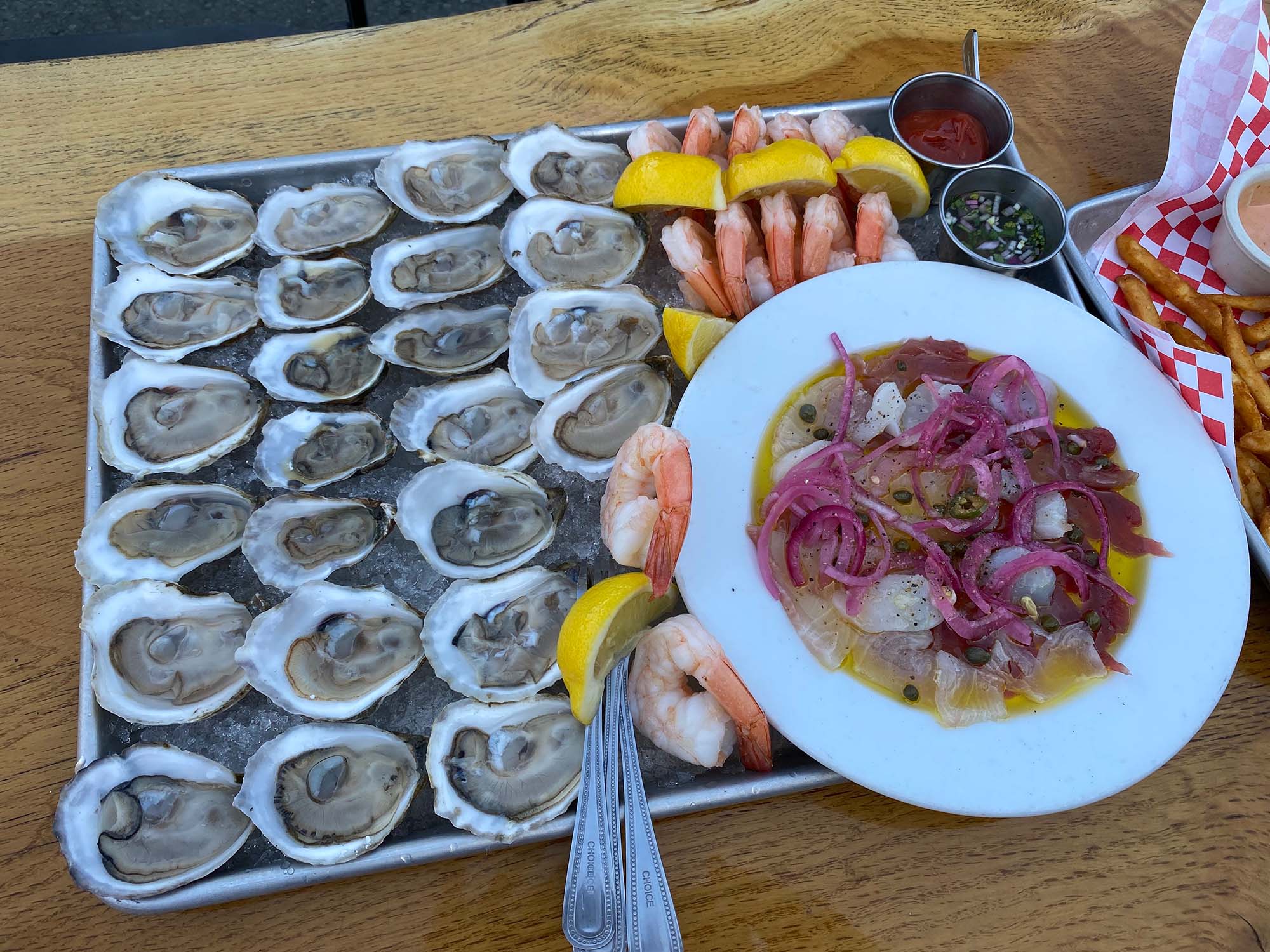 A big tray of oysters, crudo, and shrimp cocktail.