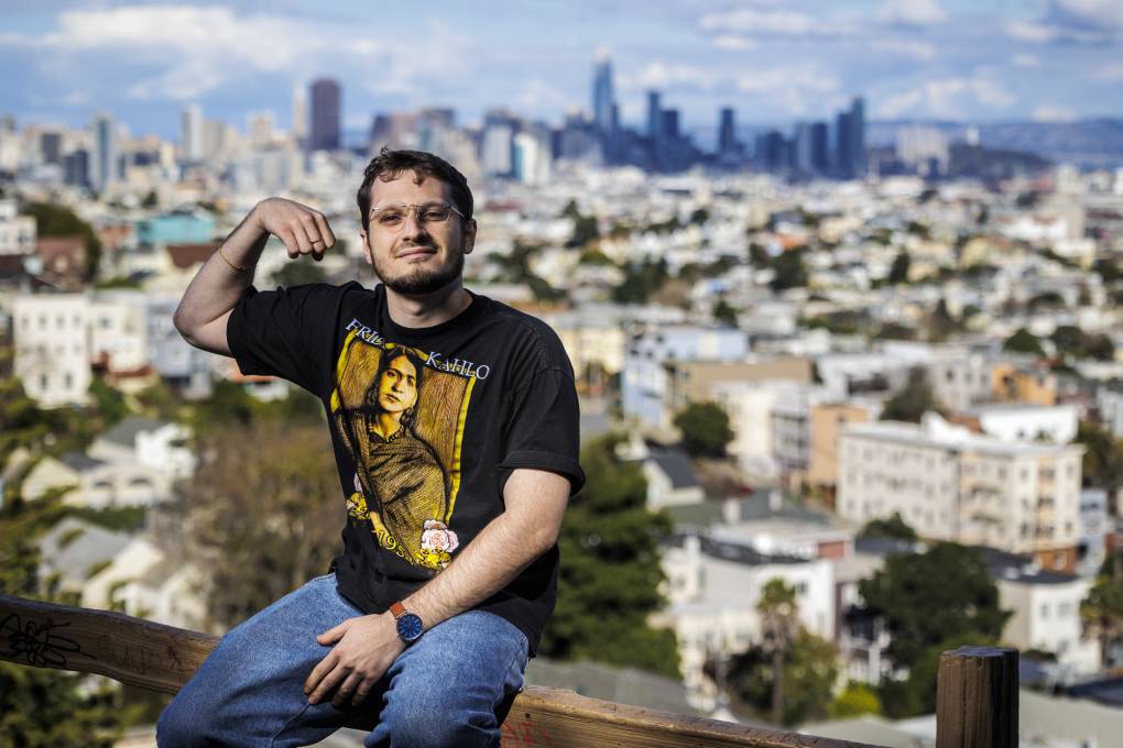Rapper Frak sits in a park overlooking a view of the San Francisco skyline.