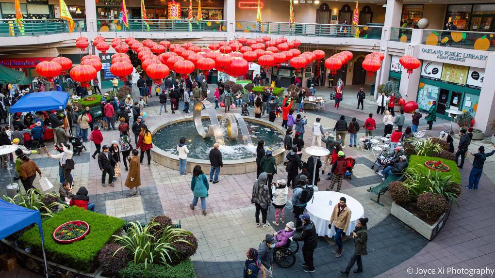 A plaza in Oakland Chinatown decorated with red paper lanterns