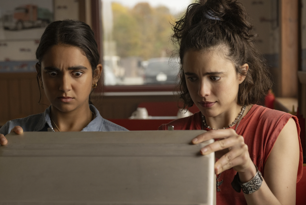 Two young women gaze wide-eyed into an open silver brief case.