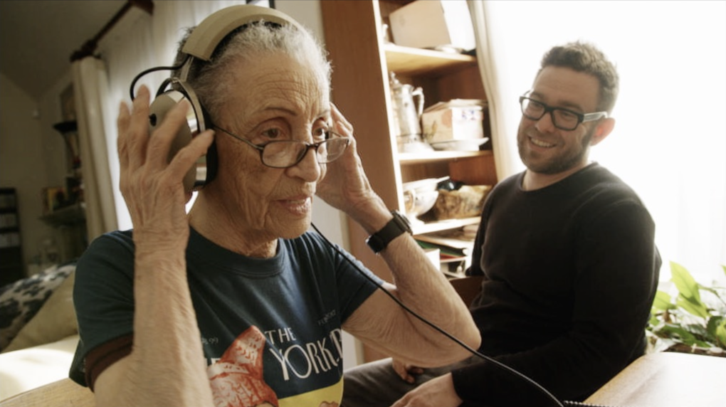 Betty Reid Soskin listening to her own music as film director Bryan Gibel watches.