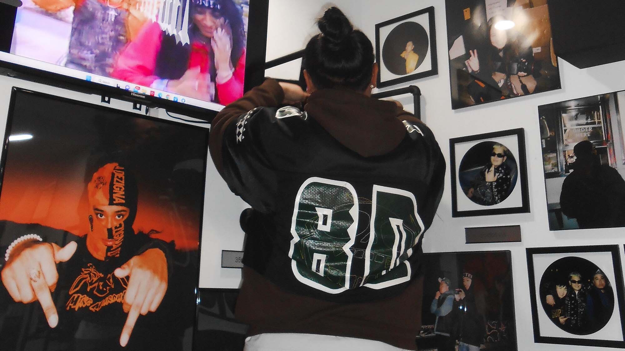 an artist puts photographs up on a studio wall before an exhibition
