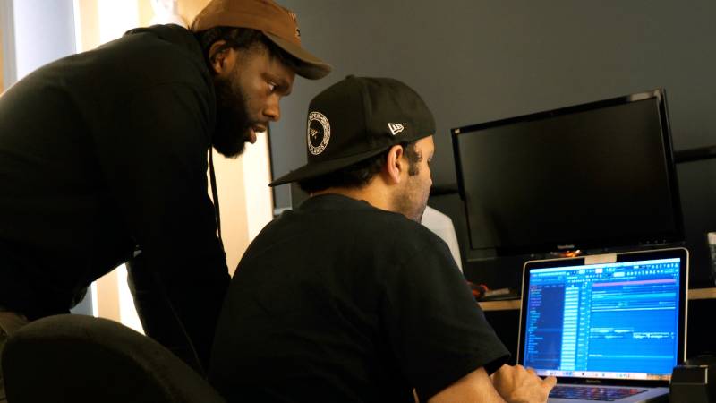 Two artists look at a computer together. 