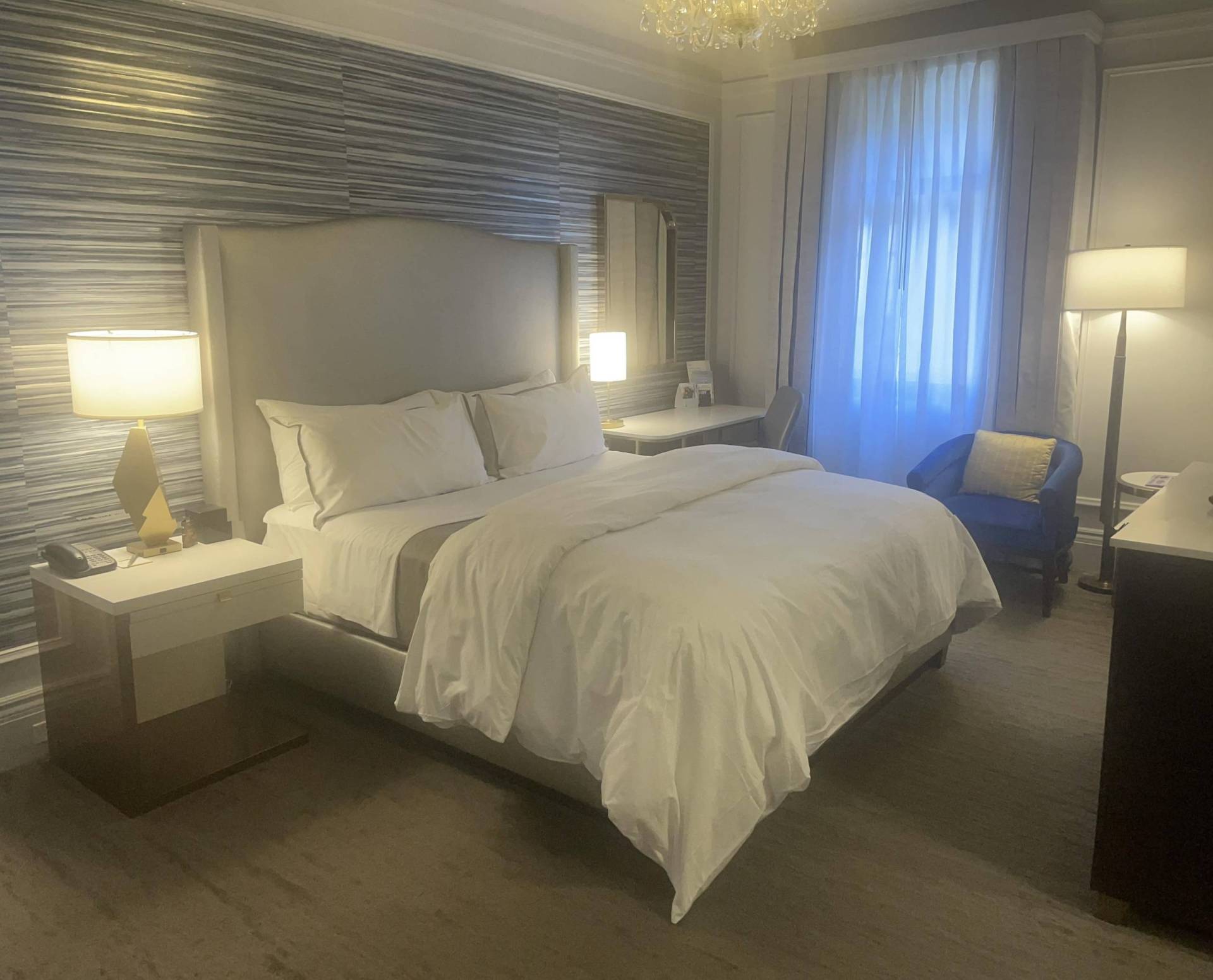 A modern hotel room with a queen sized bed.