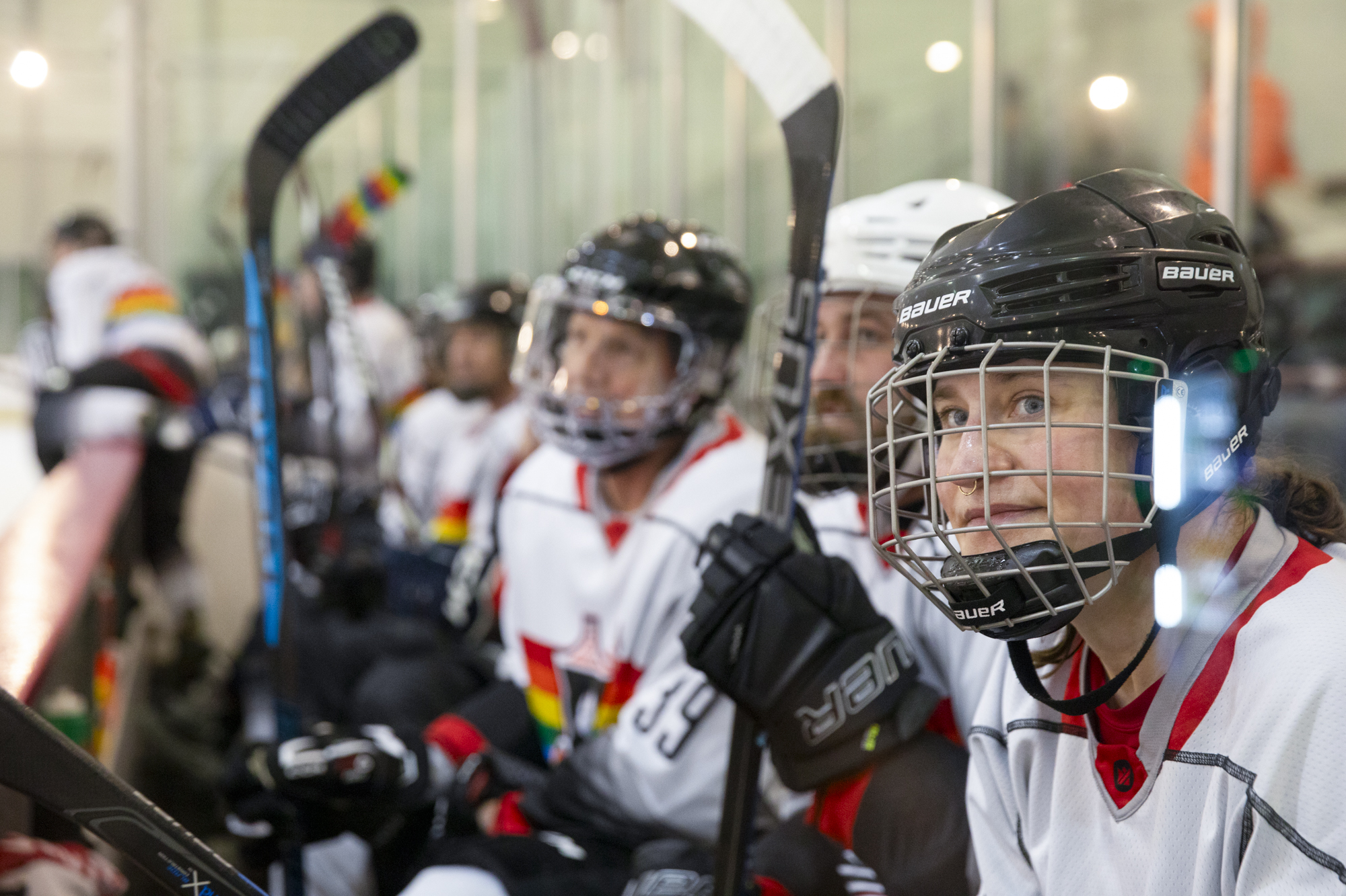 Hockey players line up at the edge of the rink.