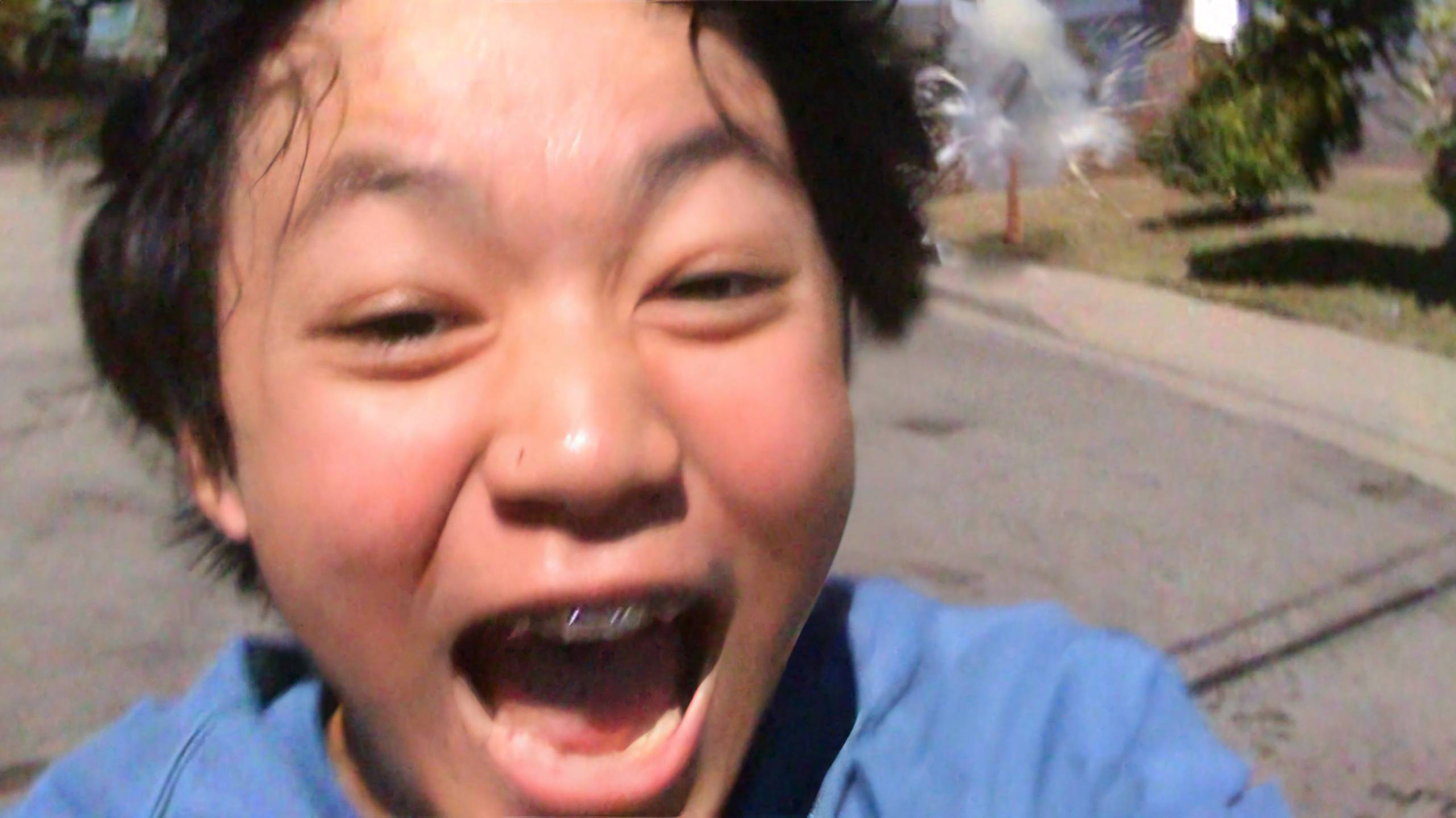 Close-up of face of young person with mouth open, in motion