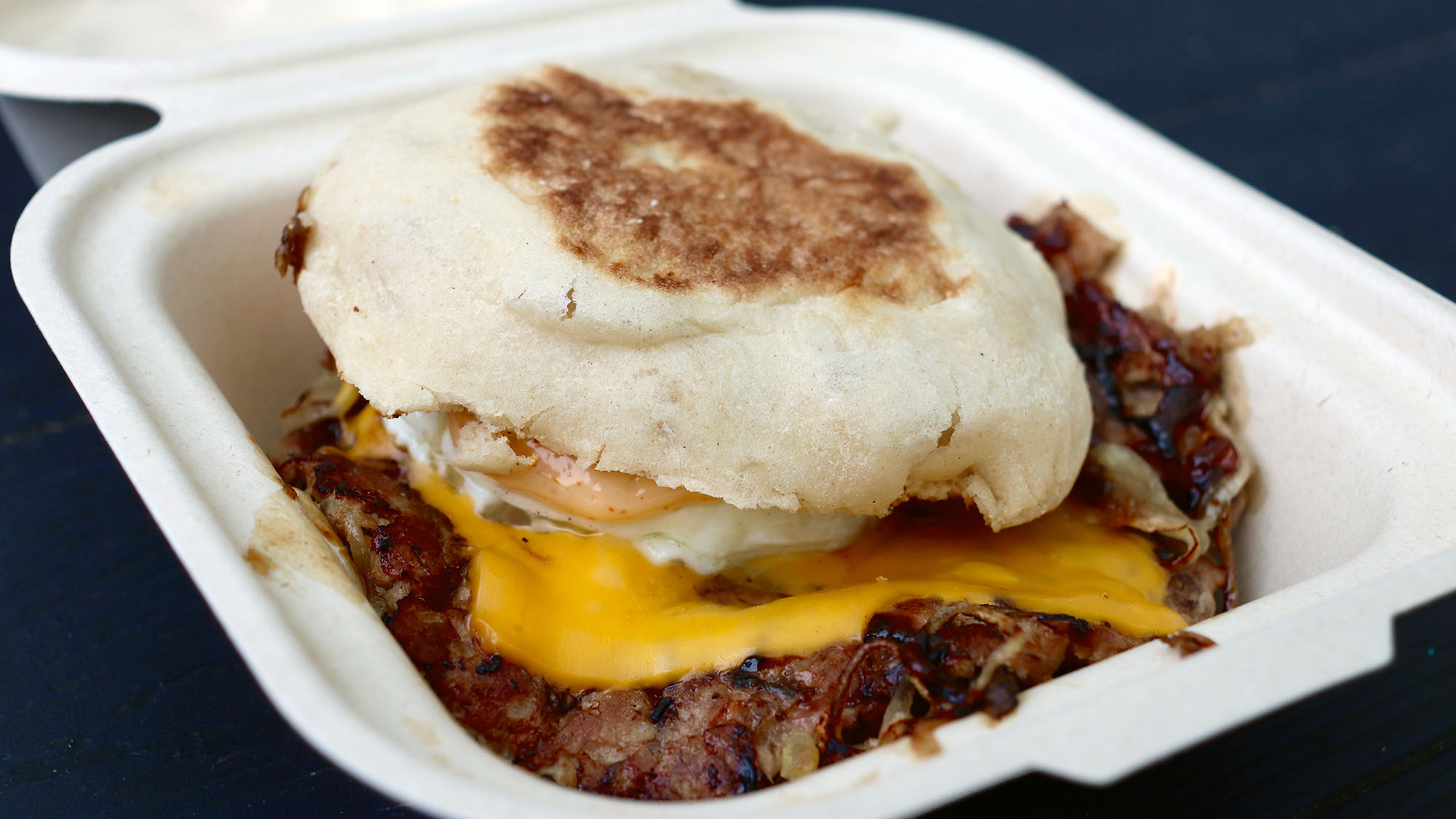 a breakfast sandwich is served in a to-go box