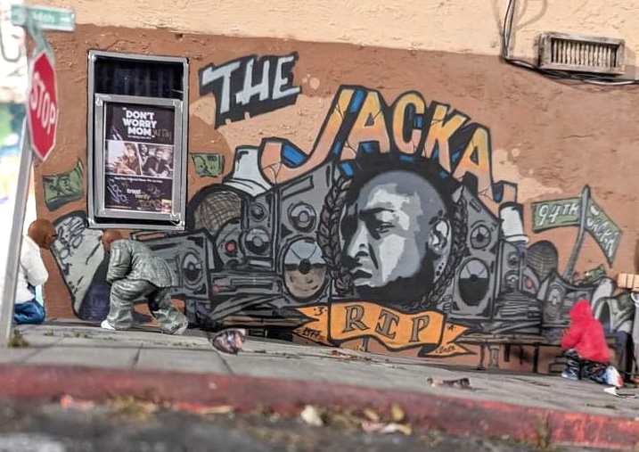 An artistic depiction of a mural, on a street corner, that reads 'The Jacka' and pictures a Black man surrounded by illustrations