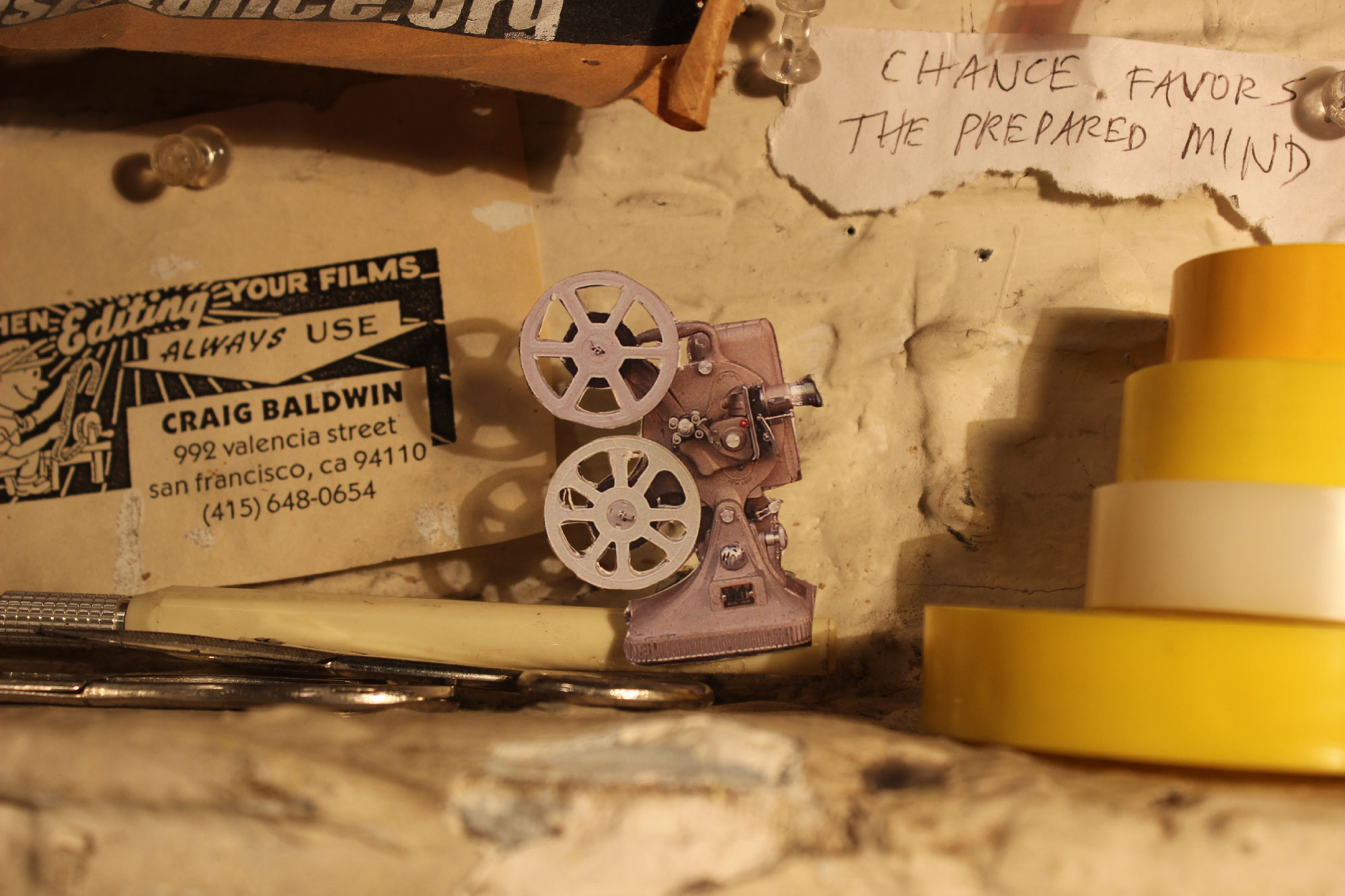 close-up view of business card, paper projection machine and stack of tape rolls