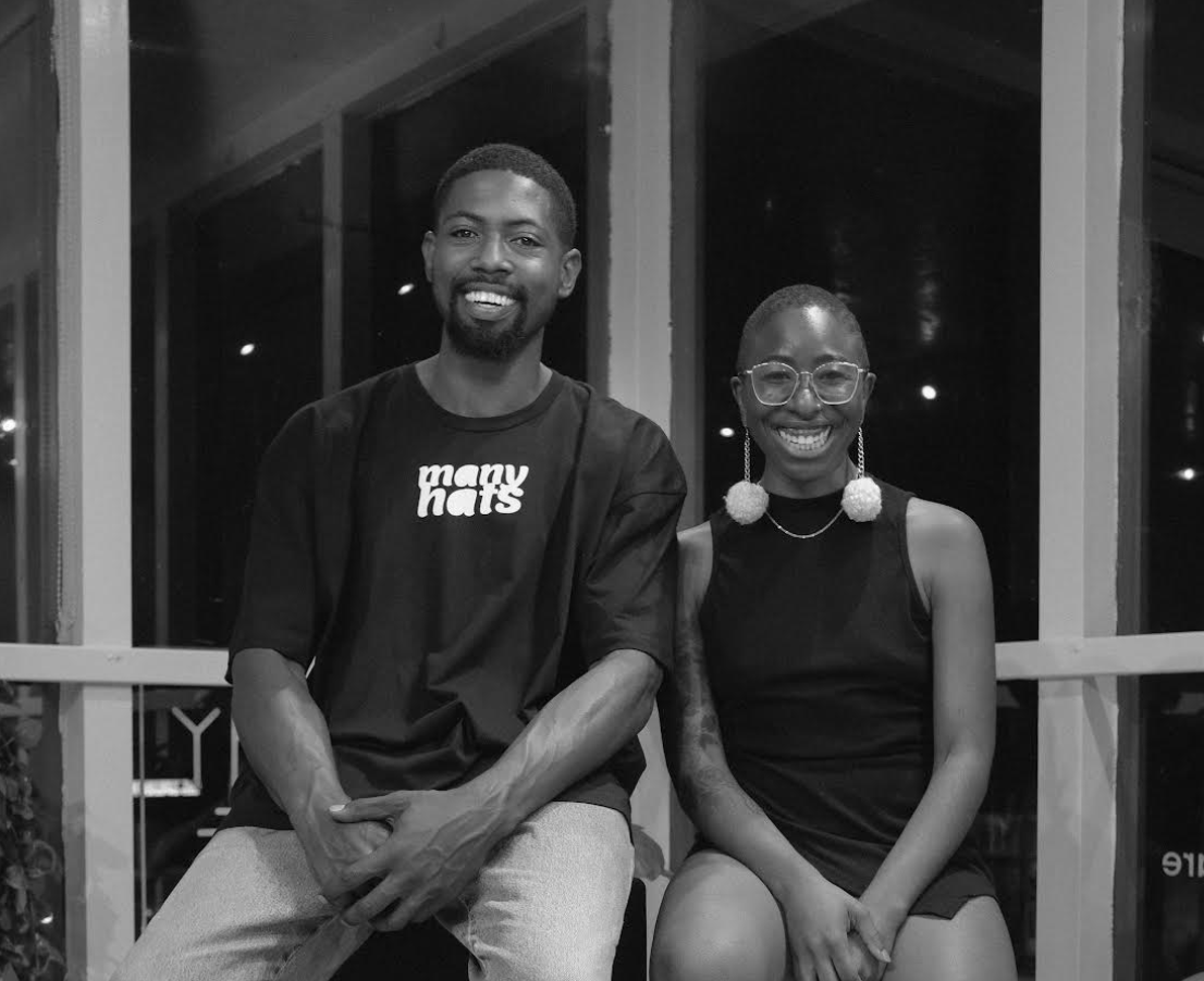 Andreas Tillman Jr. and Camille Janae sit next to each other, looking at the camera as they pose for a photo.