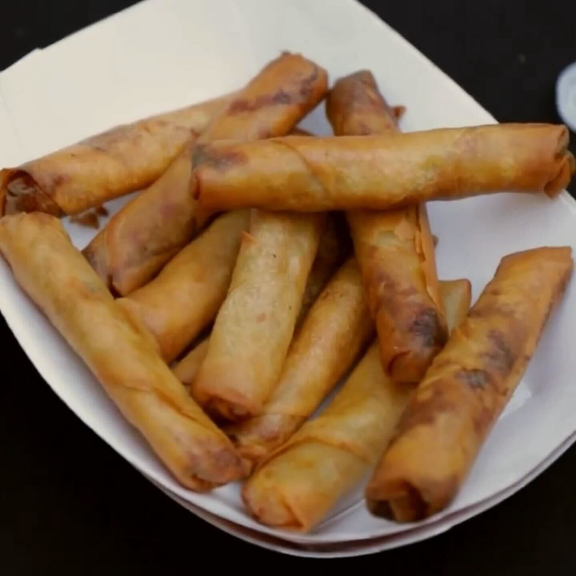 a paper tray of lumpia rolls are served during an eating competition