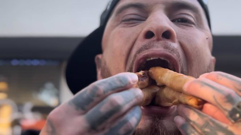 a man shoves four lumpia rolls into his mouth during an eating contest