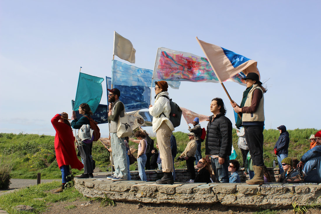 A photo of people looking into the distance while waving colorful flags.