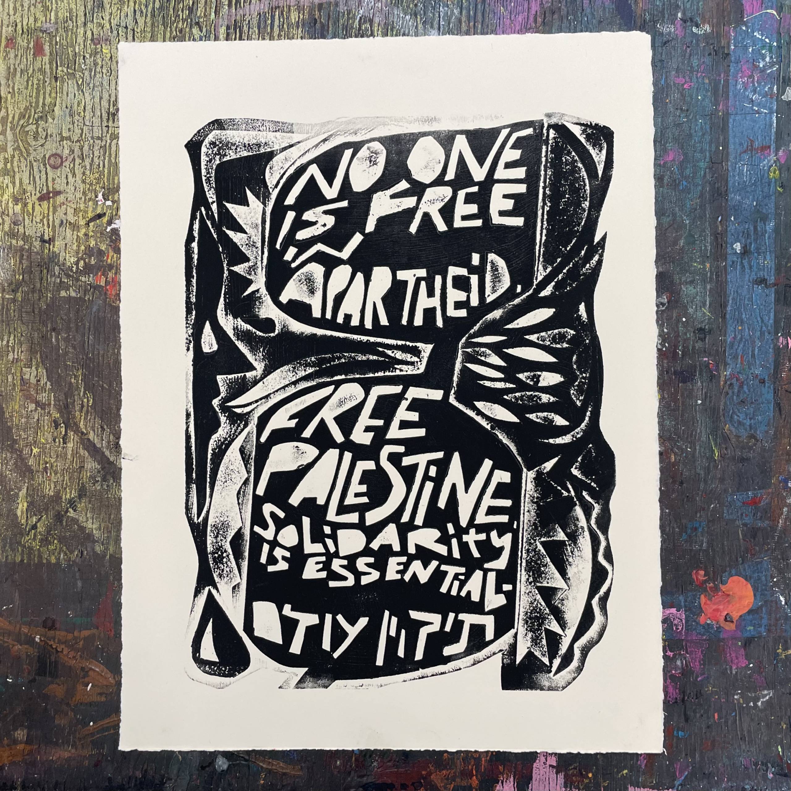 A print that says "No one is free in apartheid. Free Palestine. Solidarity is essential."