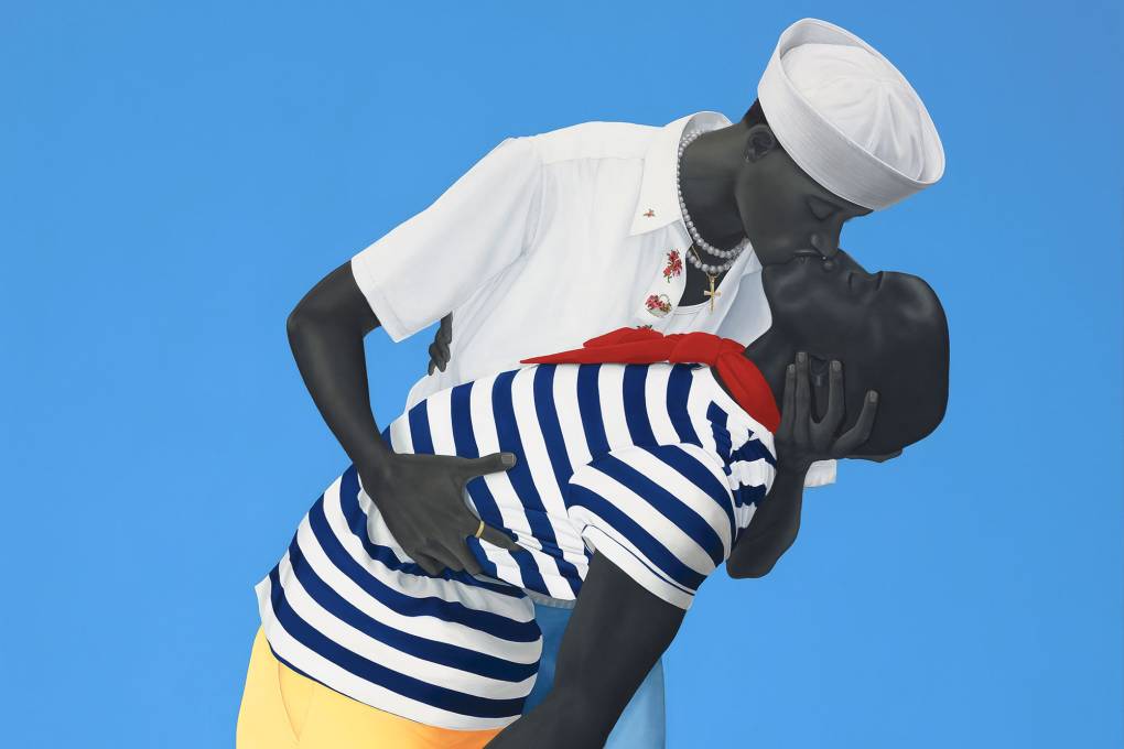 Two grayscale figures kiss in dramatic pose wearing sailor-like clothes against blue background