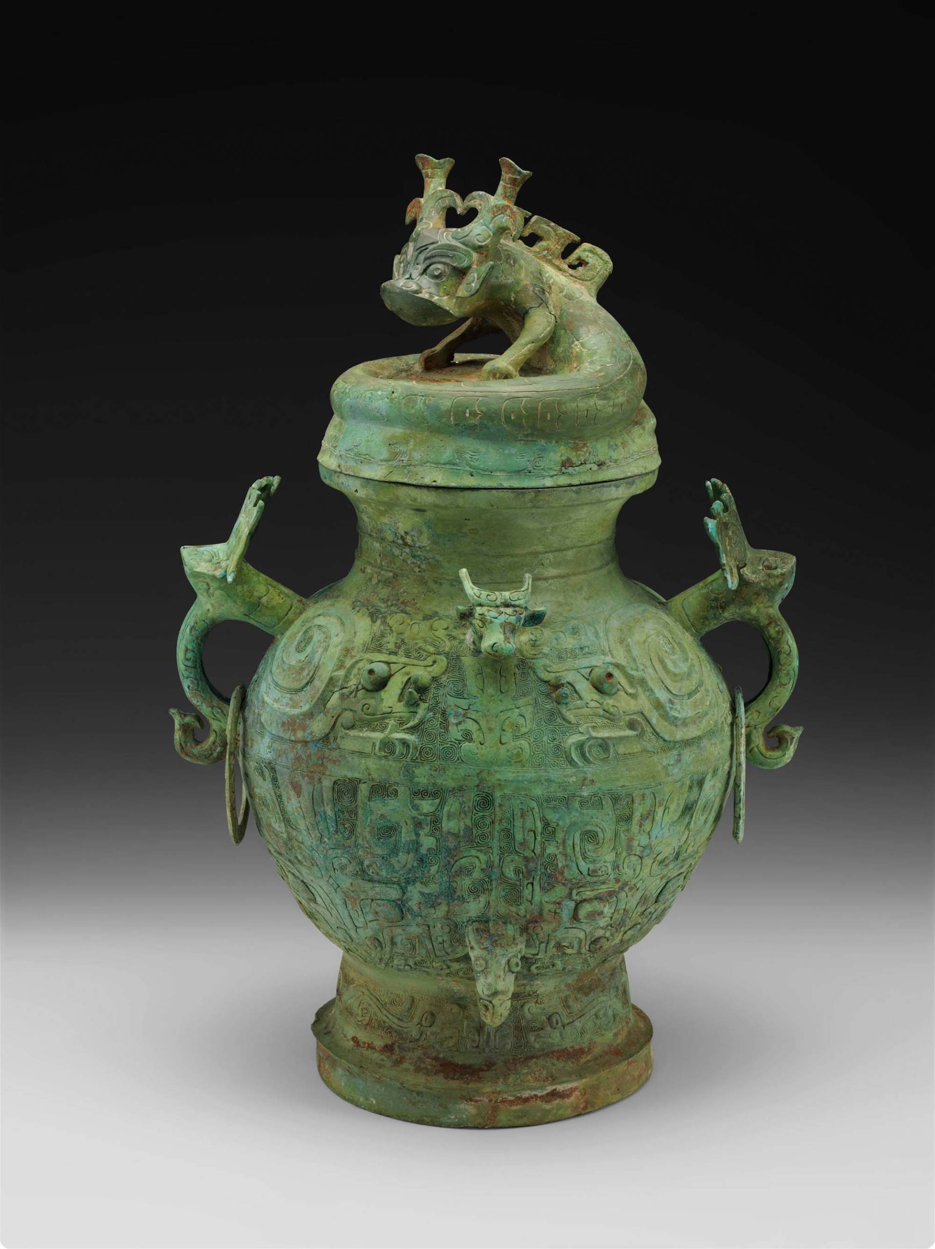 Green ancient Chinese wine vessel with dragon carving.