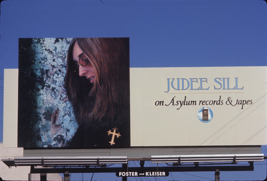 Billboard with album cover and information set against blue sky