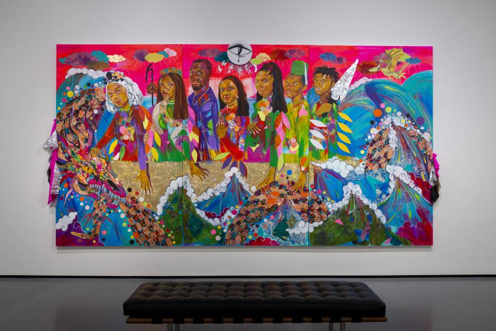 A colorful painting hangs on a wall in a gallery