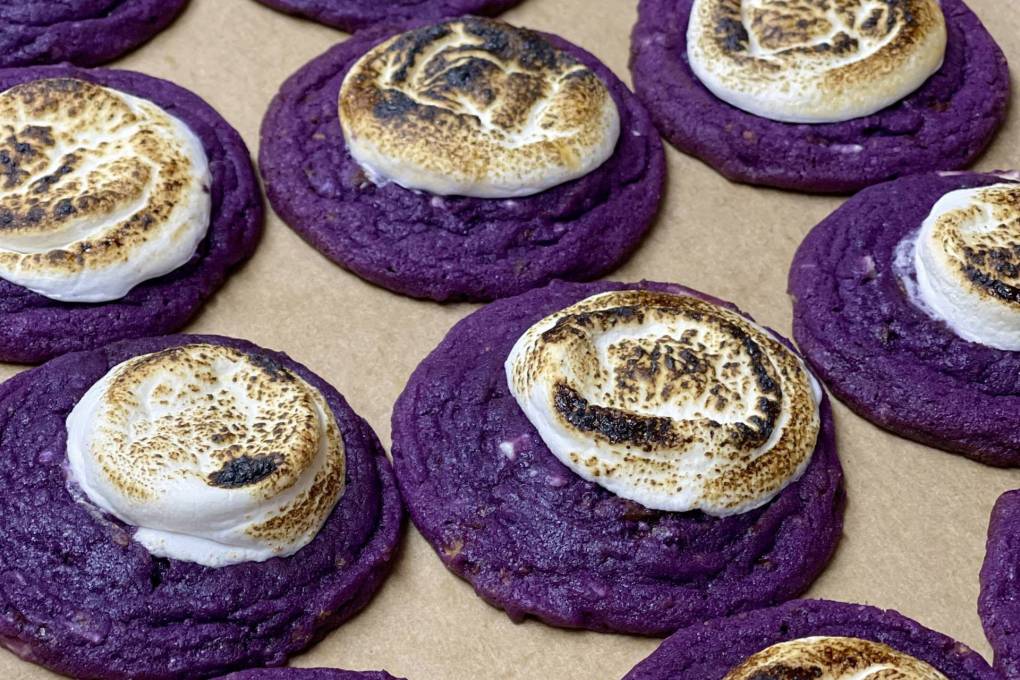 a fresh batch of purple ube cookies with toasted marshmallow are laid out by the dozen