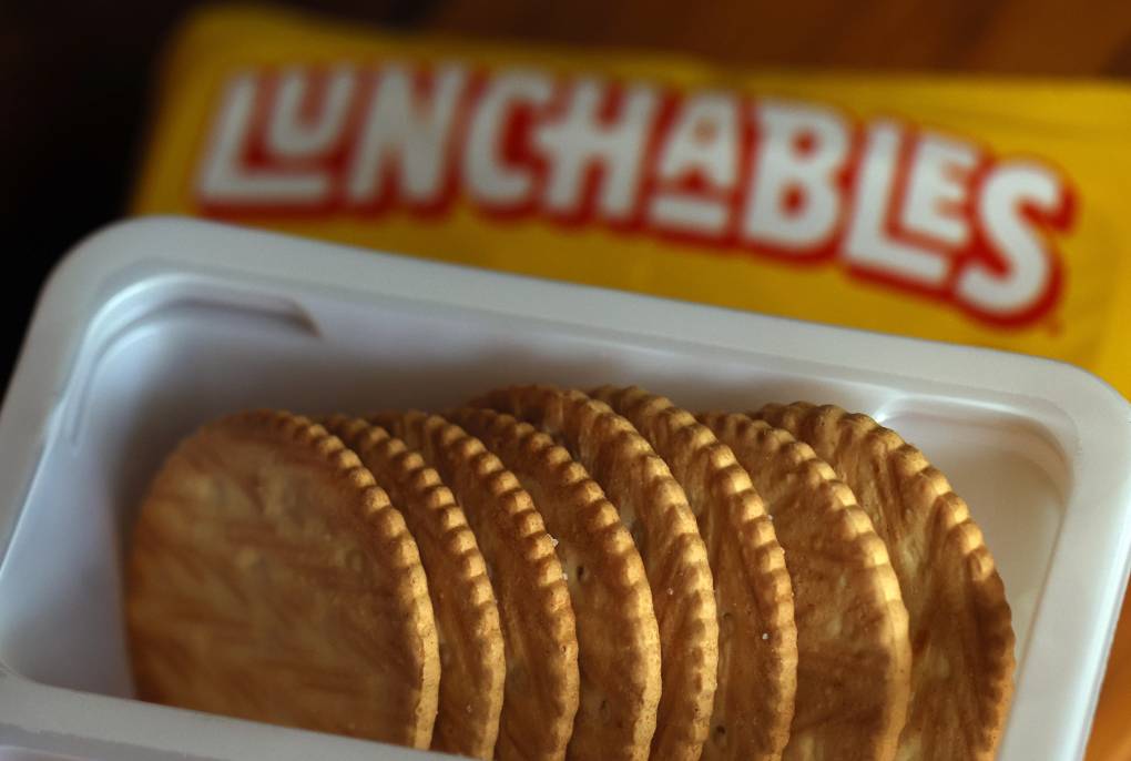 A close up of round crackers sitting in a white plastic container.