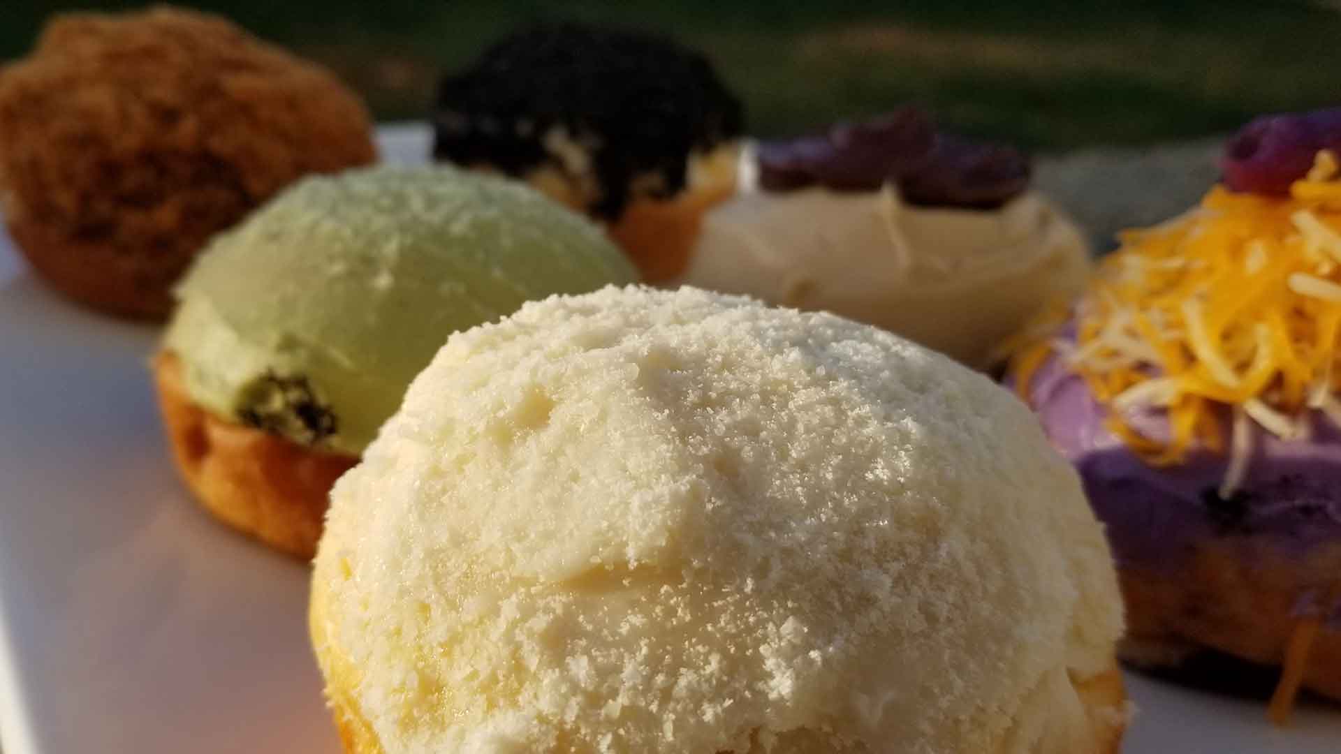 White, green and multi-colored cupcakes on a white counter