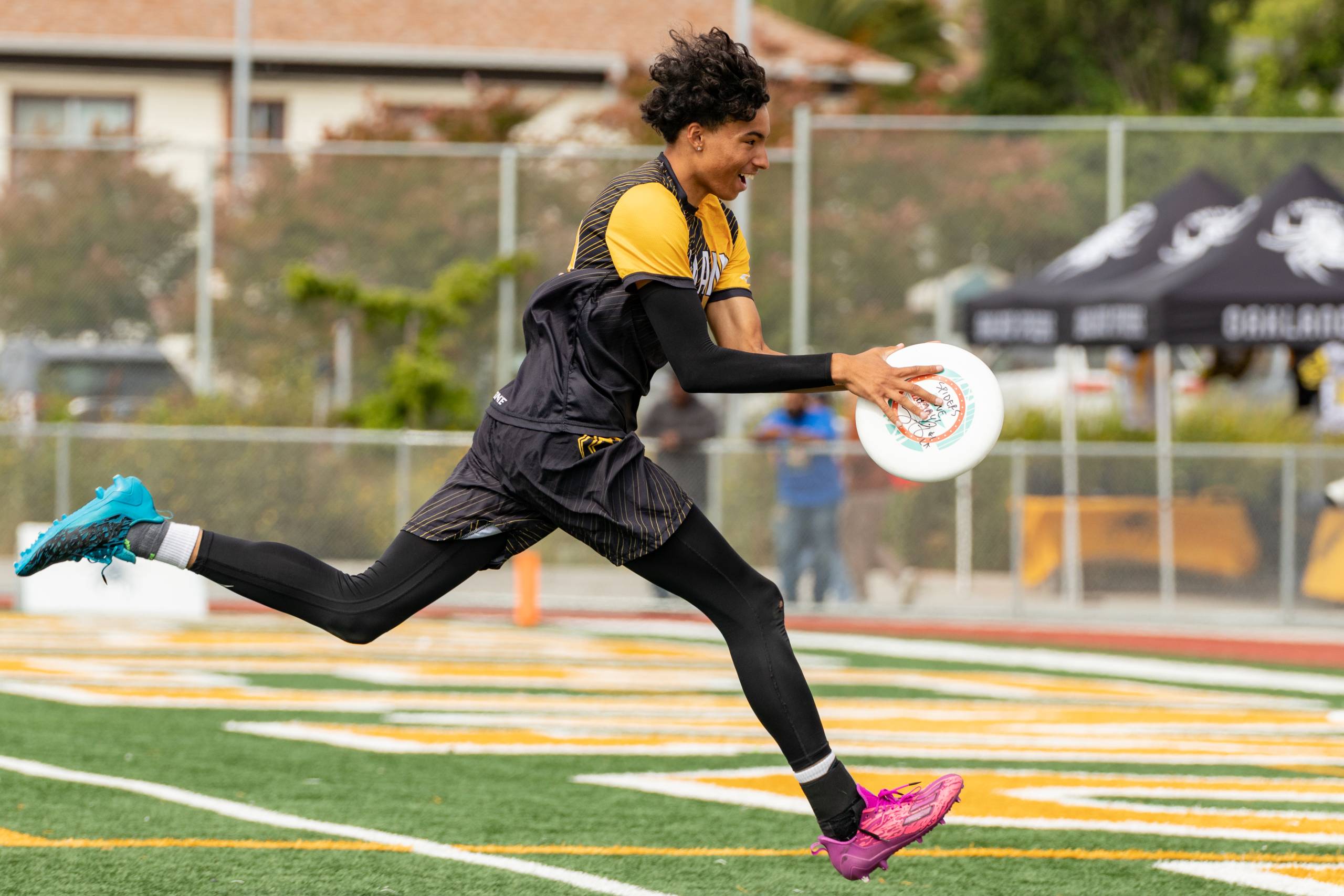 an ultimate frisbee player runs for a score with frisbee in hand