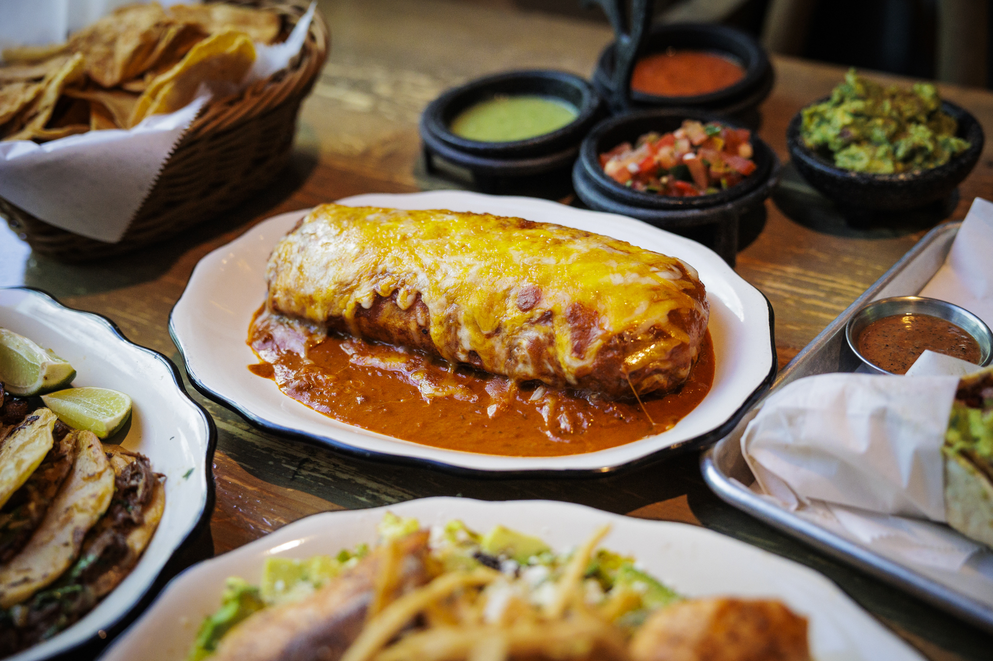 A sauce-drenched wet burrito on a plate.