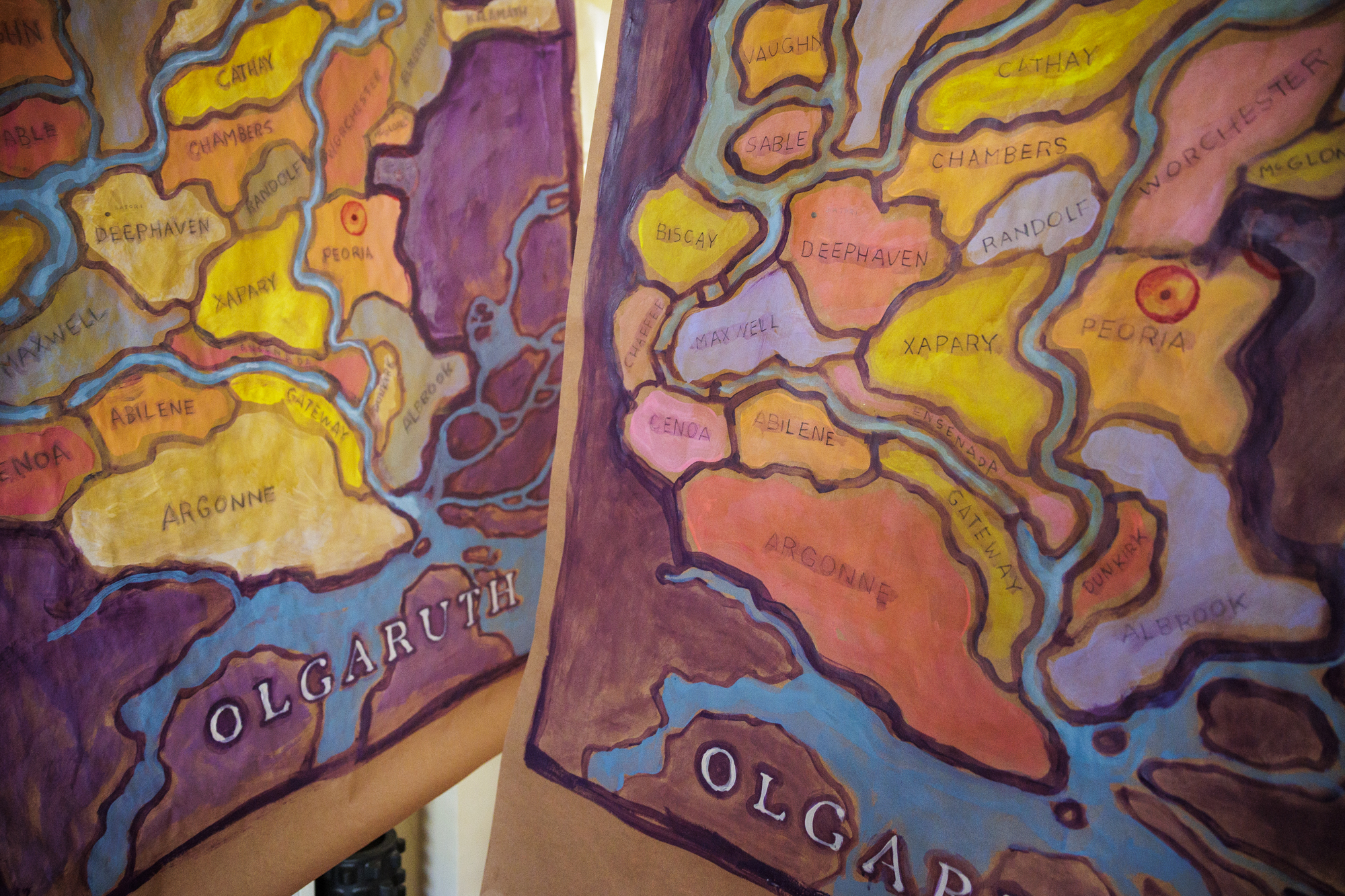 Two brightly colored map paintings showing regions of a landscape