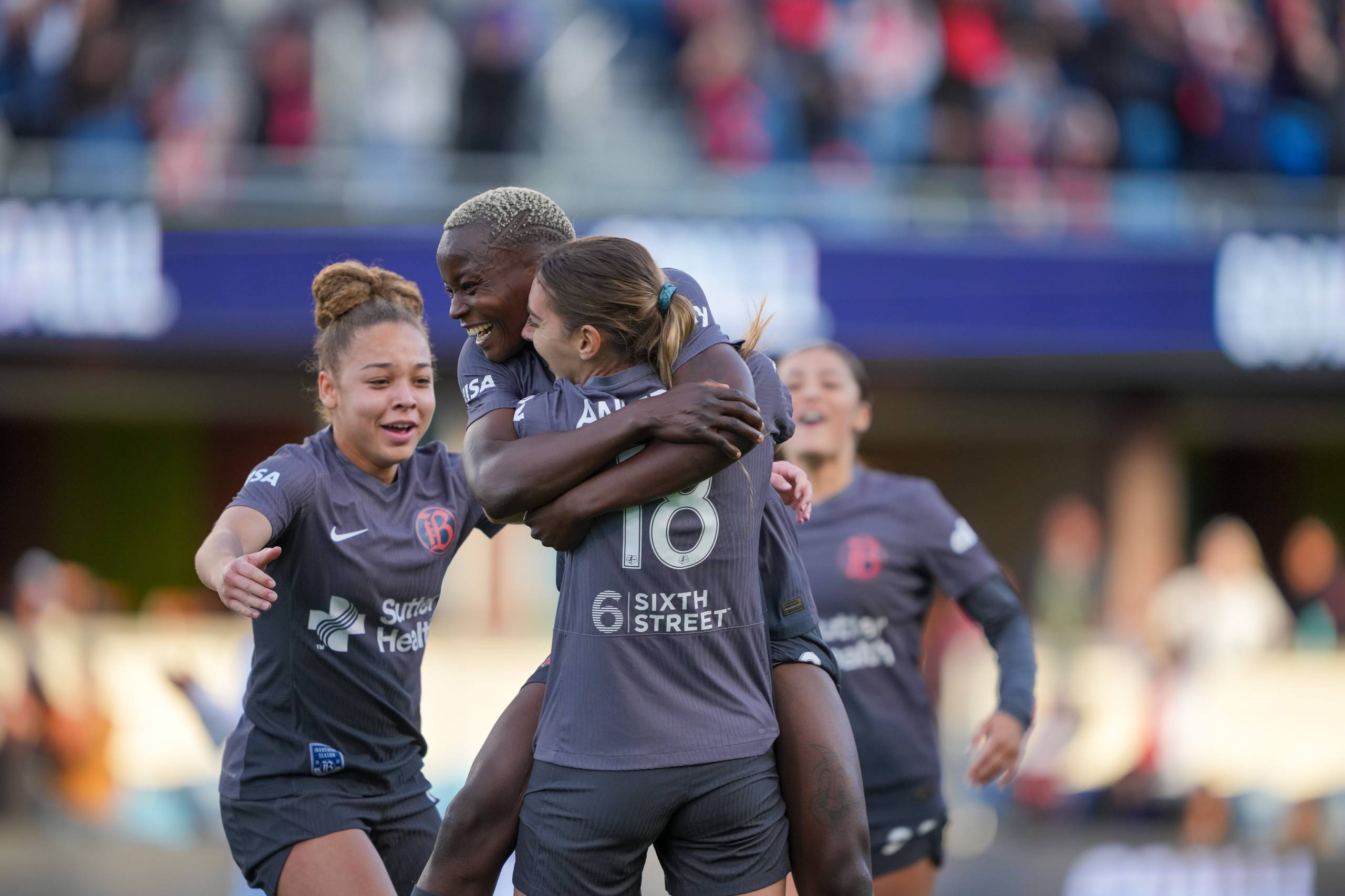 a group of women soccer players celebrate after a goal is scored