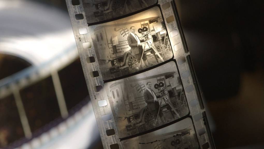 strip of 35mm film showing a man with an old film camera