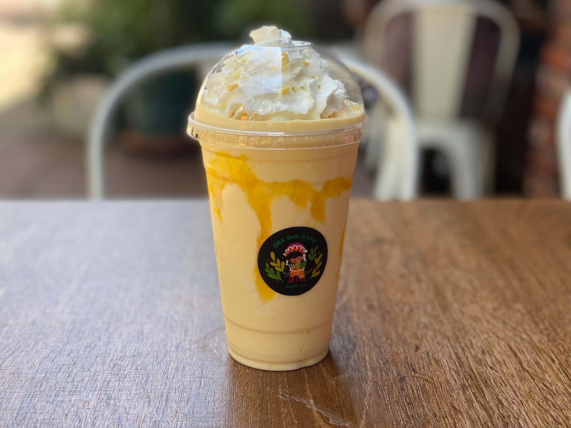 A mango smoothie topped with whipped cream.