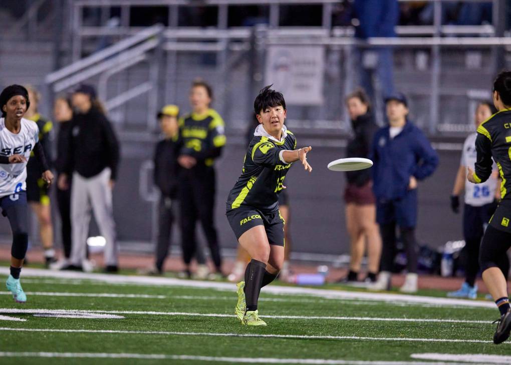 an ultimate frisbee player throws a disc from midfield