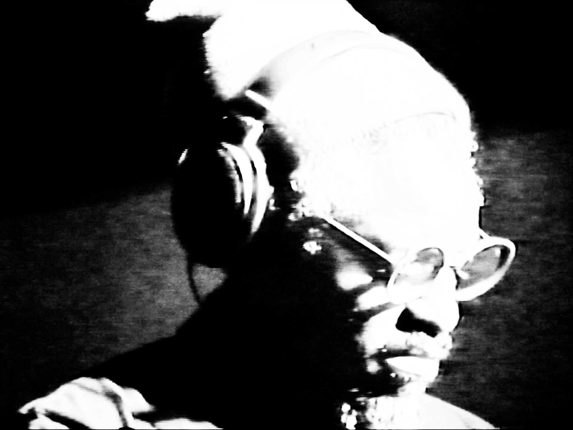 Black and white image of rapper André 3000 wearing headphones.