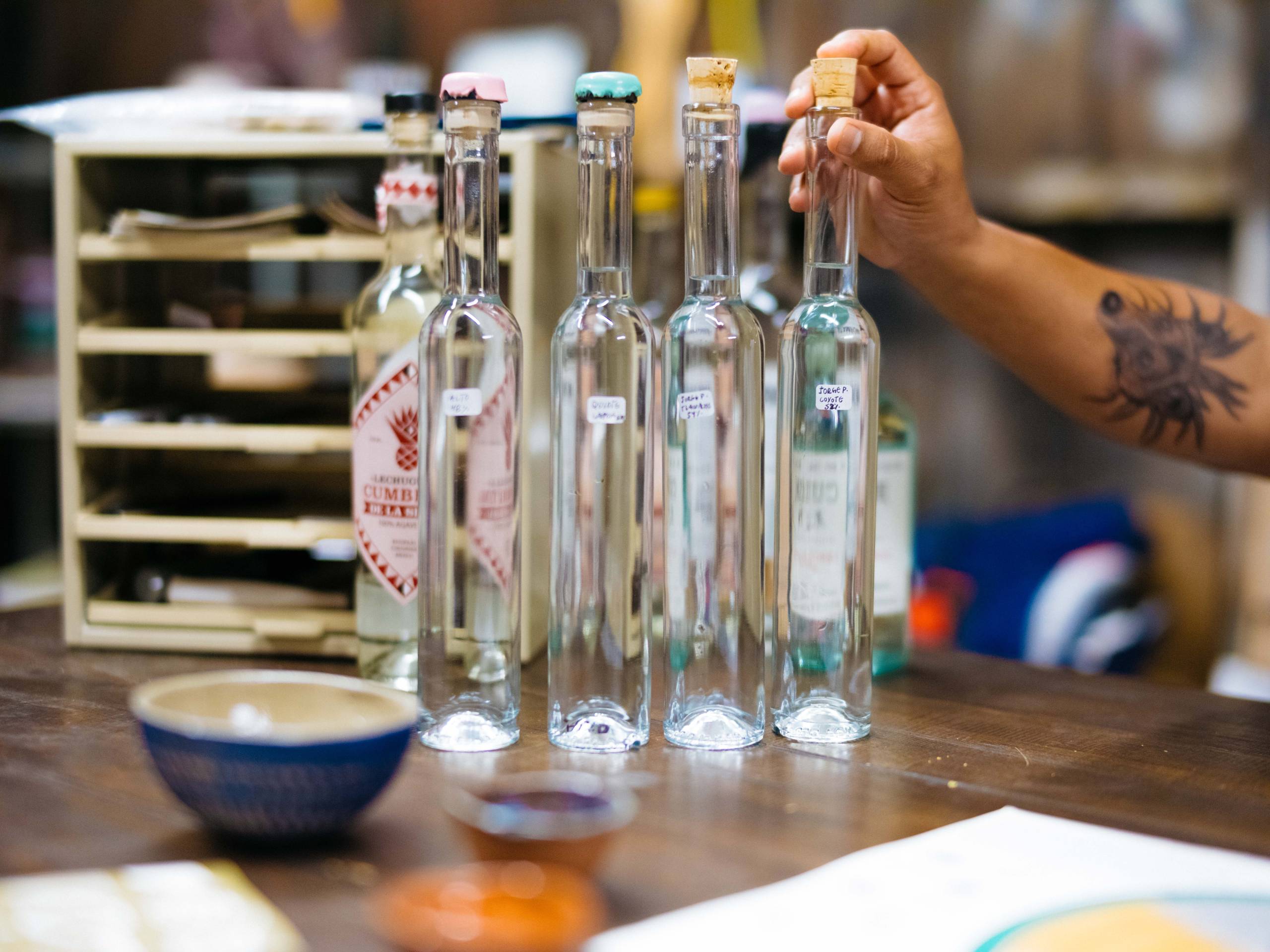 four bottles of mezcal from Mexico displayed on a table
