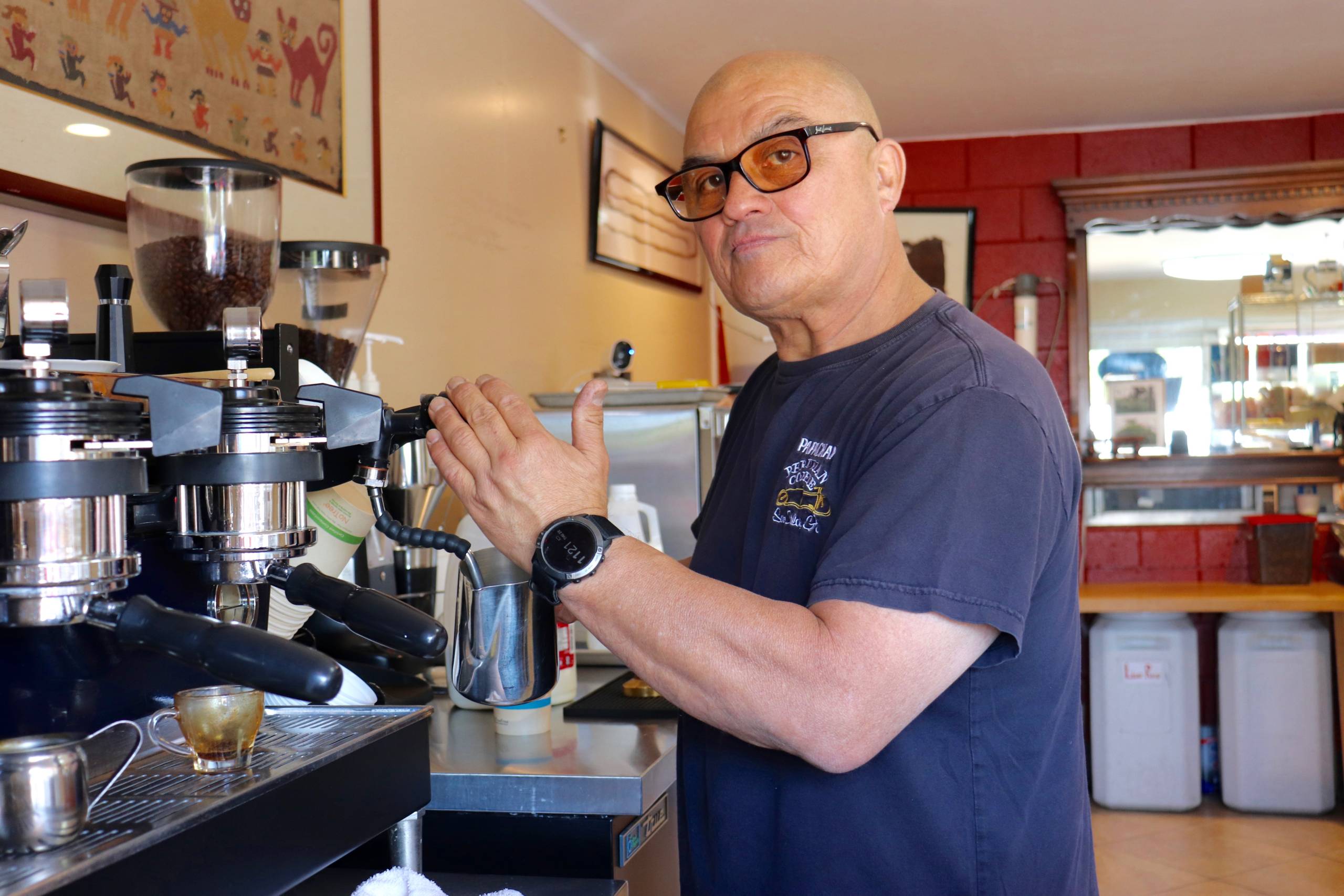 a man prepares a cup of fresh coffee inside a Peruvian cafe