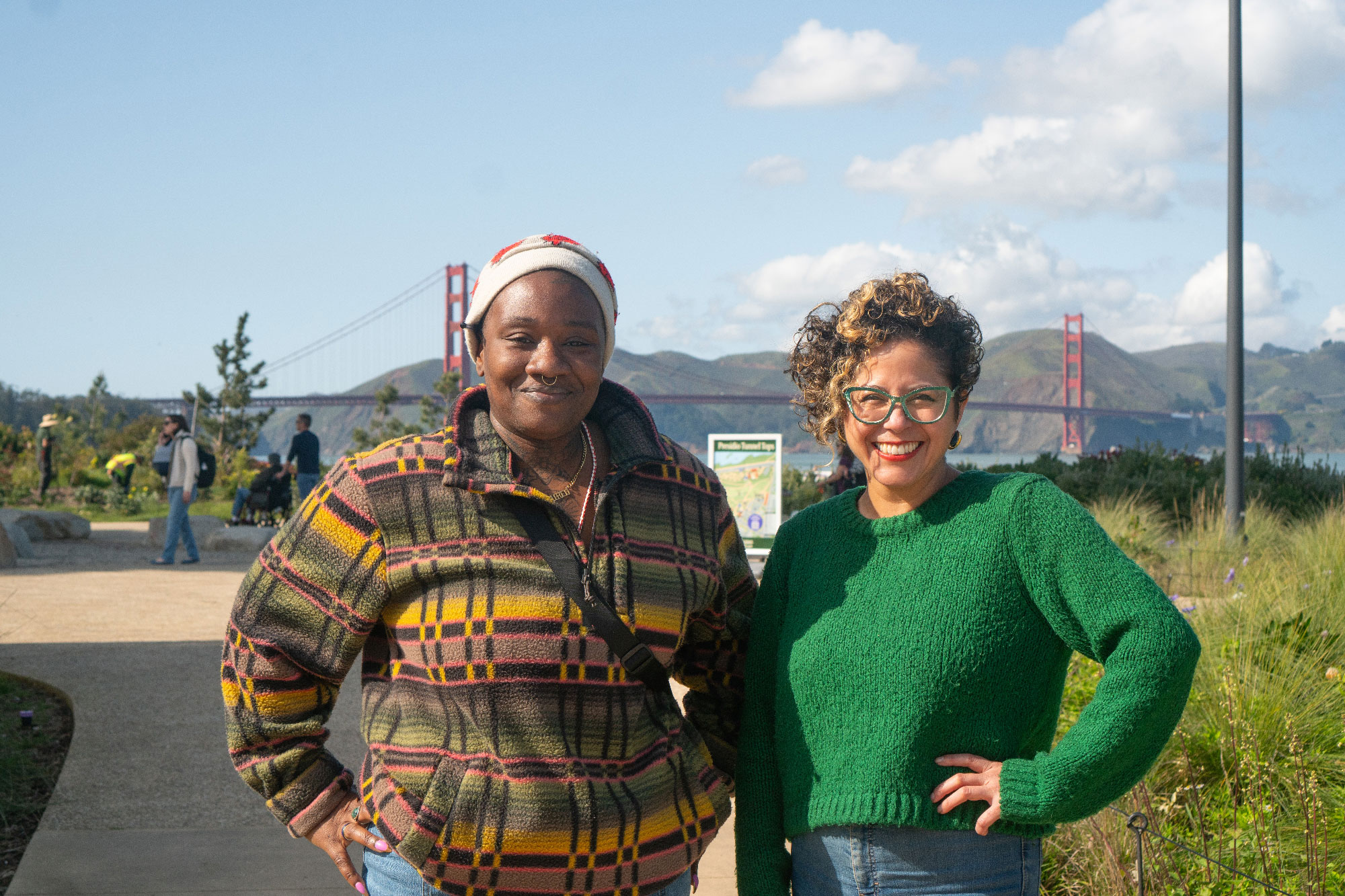Two people pose smiling with Golden Gate Bride in background