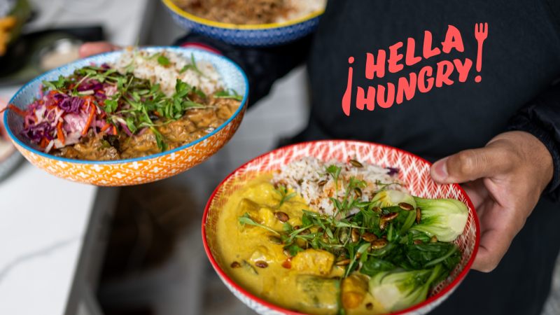 A chef holding two Filipino dishes, including a coconut curry topped with bok choy.