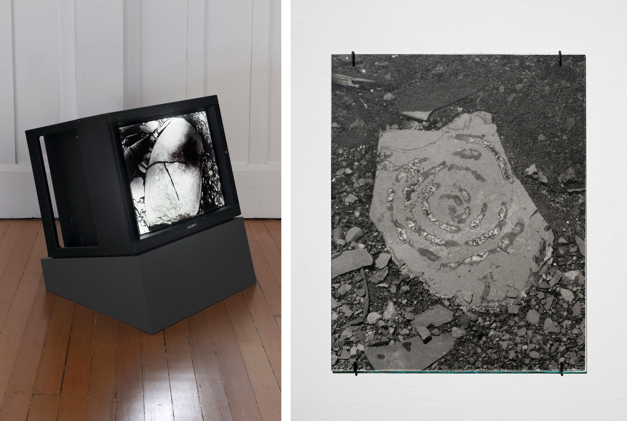 two images, one of monitor with black-and-white video playing, the other of a photo print of a spiral painted with water on a rock
