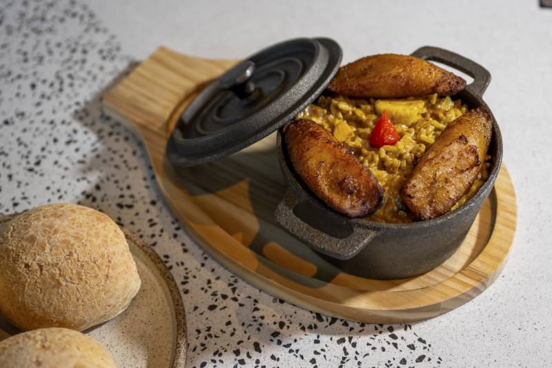 Rice, beans and plantains in a small black pot.