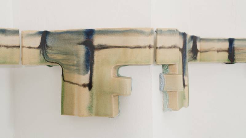 Detail of abstract glazed ceramic that covers a protruding corner in a white gallery space