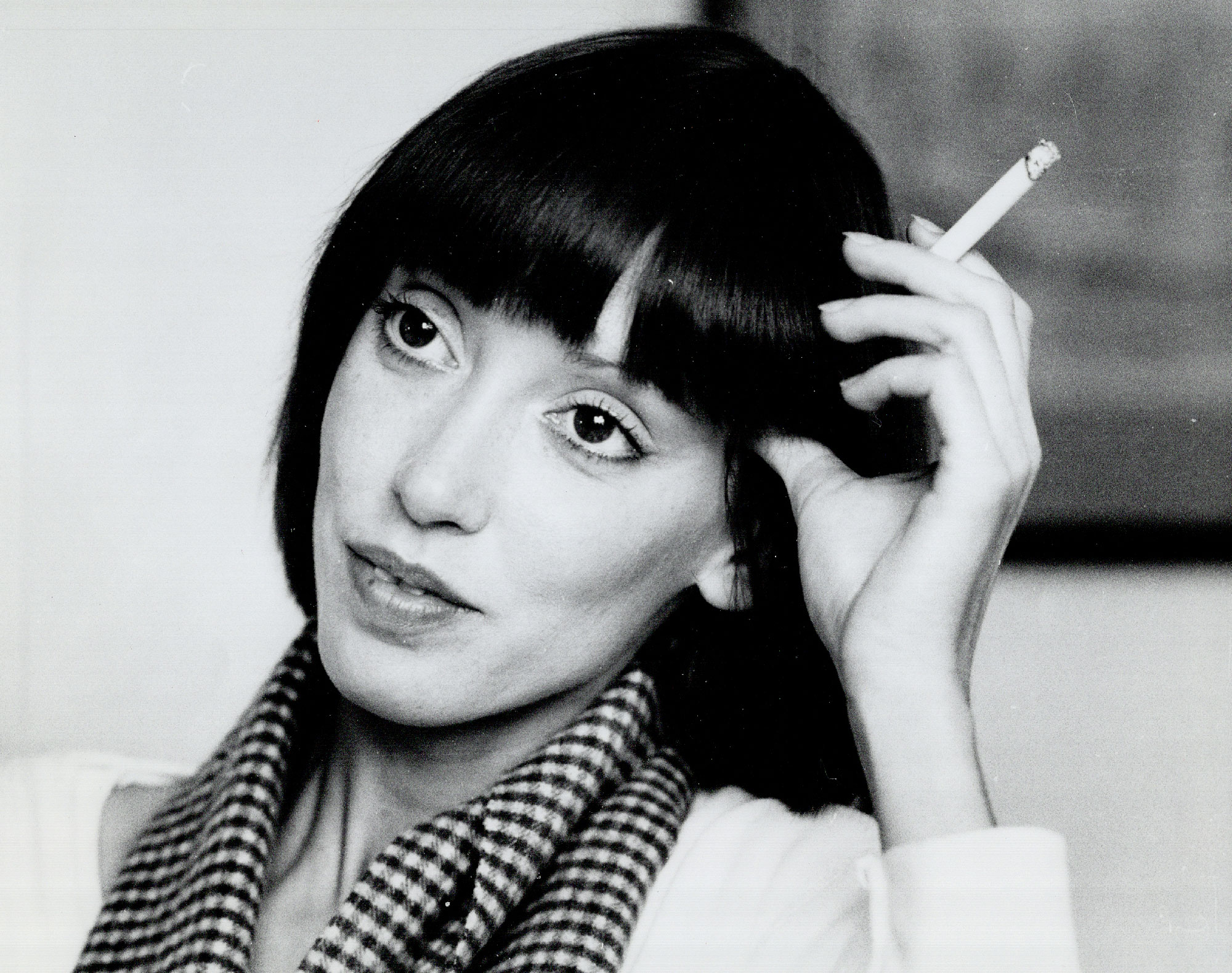 Black-and-white photo of dark-haired woman holding cigarette
