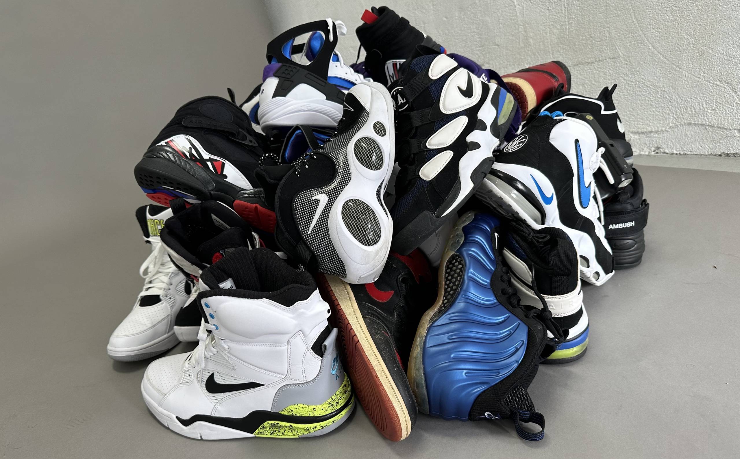 a pile of Nikes sneakers in the center of an empty room