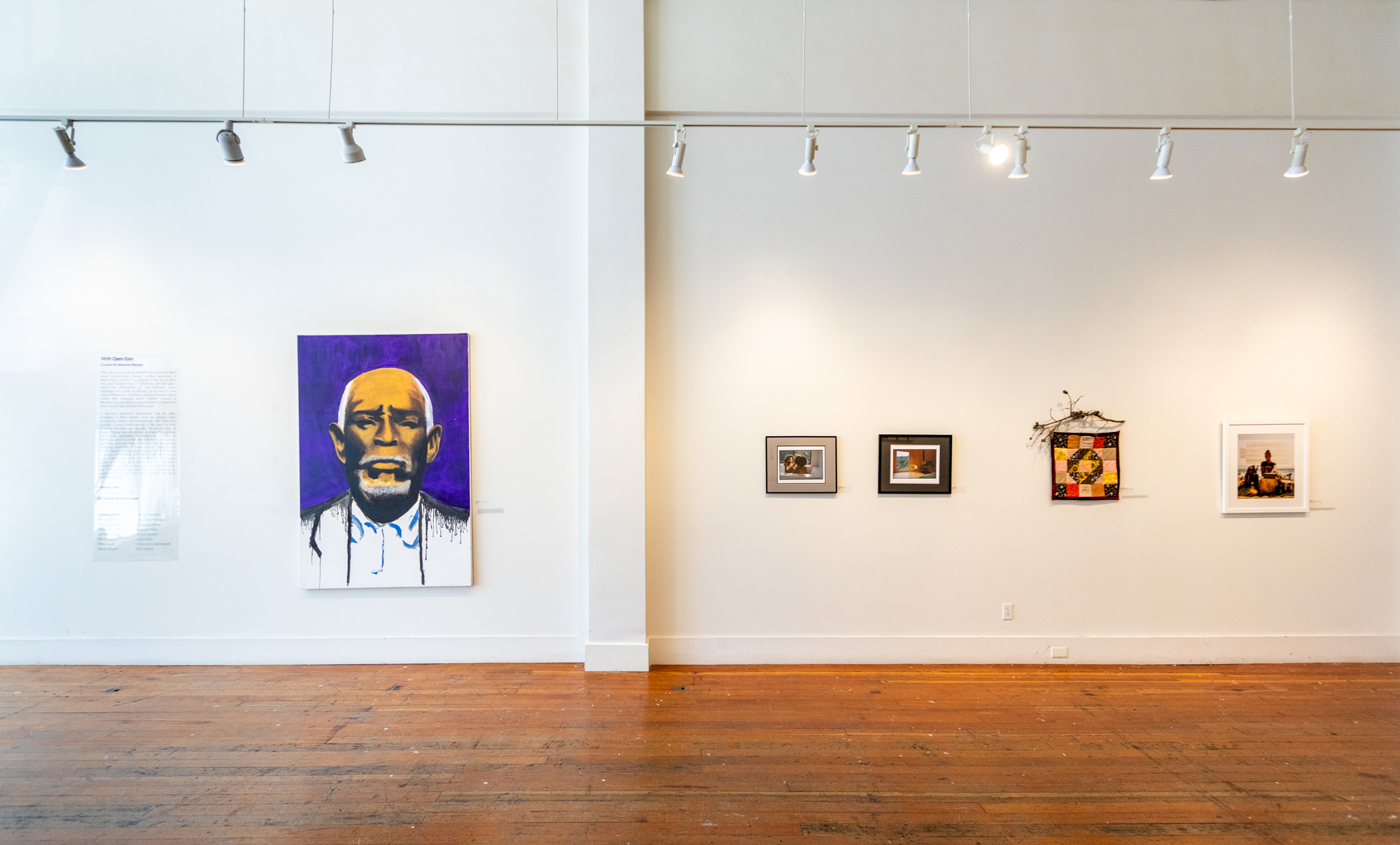 Paintings and photographs on white gallery walls
