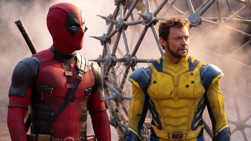 Two male superheroes stand side by side. One dressed in red and black, the other in yellow and blue.