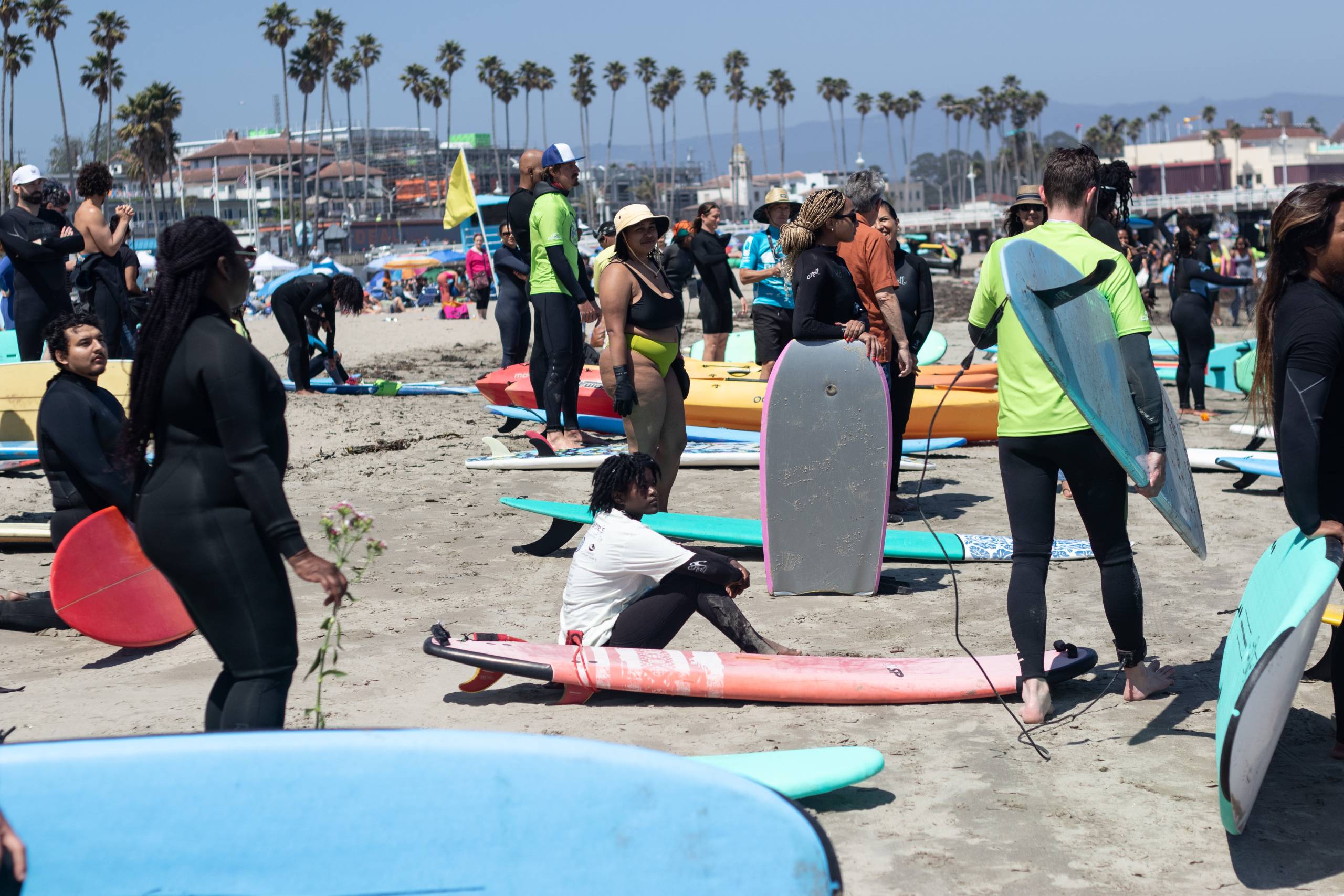 Surfers gather on a crowded beach.