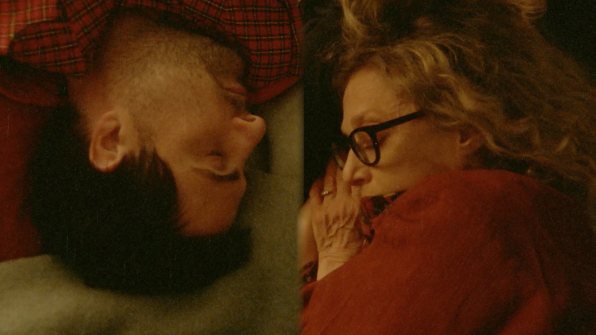 Close up of a man and woman sleeping face-to-face. He is upside down.