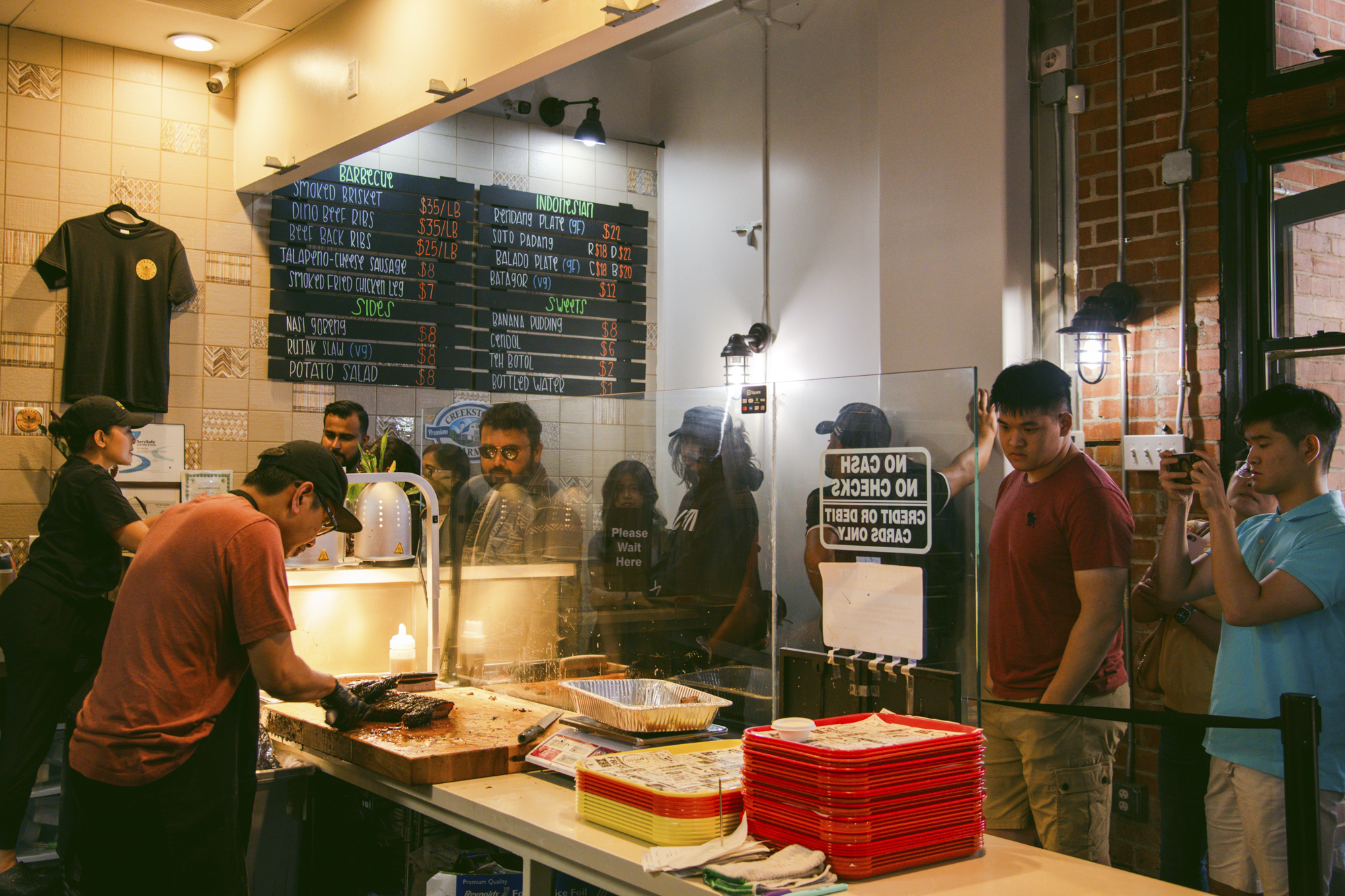 Customers order at the front counter of a barbecue restaurant.