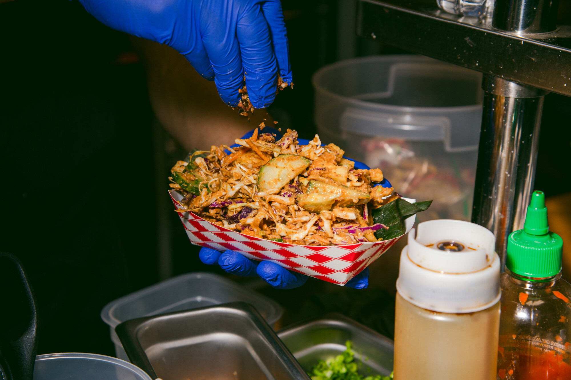 A paper sleeve of cucumber and cabbage slaw.