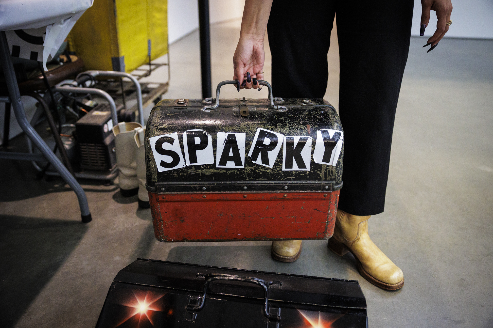 Person holding metal tool box with "SPARKY" on it