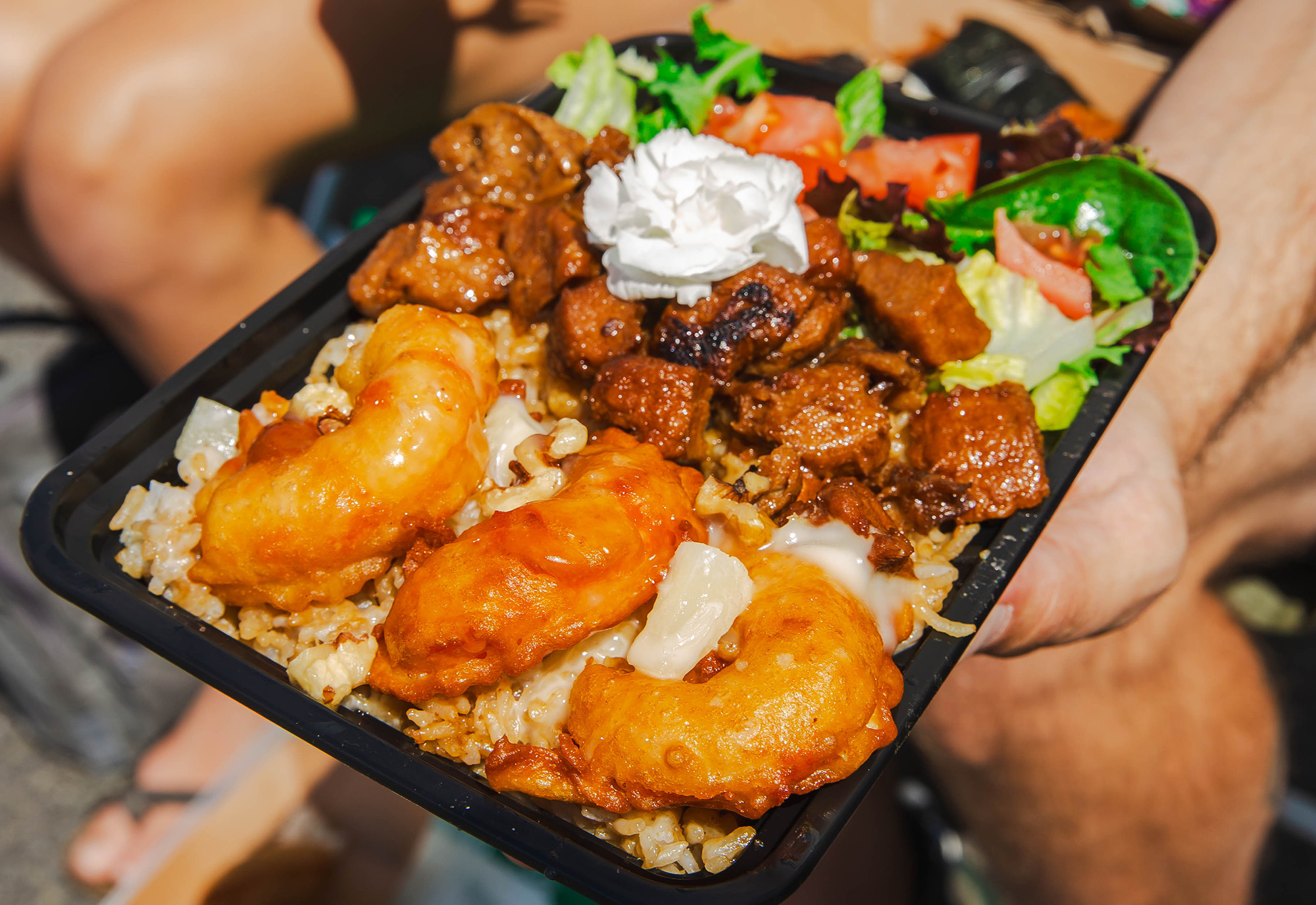 A takeout container with fried vegan shrimp, rice and salad.